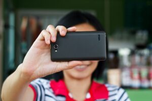 Ręki dotyka smartphone jaskrawego tło, zbliżenie