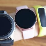 Trzy różne zegarki na rękę są noszone na zbliżenie dłoni kobiety wybór bransoletki fitness