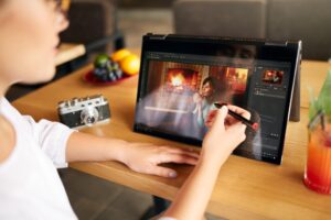Freelancer retoucher kobieta pracuje na przenośnym laptopie z oprogramowaniem do edycji zdjęć za pomocą stylusa Fotograf lub projektant cyfrowe przetwarzanie obrazu 2 w 1 z ekranem dotykowym w trybie namiotu