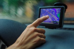 Kobieta patrząca na drogę na mapie Nawigator GPS siedzący za kierownicą samochodu w deszczowy dzień