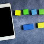 Telefon komórkowy z ważną wiadomością na biurku z pustym notatnikiem i notatkami Ekran telefonu komórkowego z kluczowymi informacjami na stole z notatnikiem i notatkami