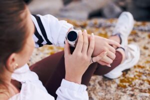 Fitness kobieta i inteligentny zegarek podczas górskich wędrówek, ćwiczenia lub wydajność, zdrowie i zegar Stoper cyfrowa technologia sportowa i ręce sprawdzają postęp aplikacji wellness i czas treningu na sprzęcie gps